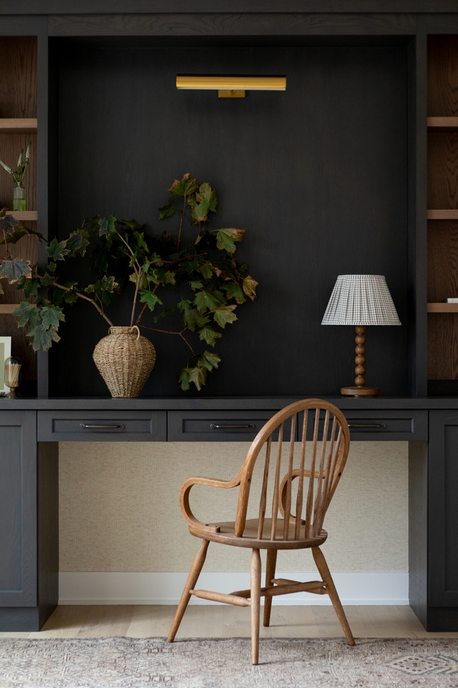 Study with custom cabinets stained in a rich dark color and textured neutral wallpaper