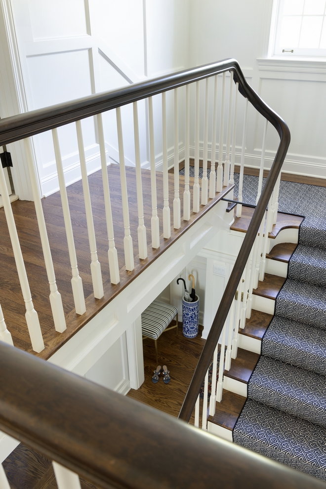 A timeless staircase showcasing white spindles painted in Benjamin Moore White Dove complemented by dark railings and treads that are stained to match the hardwood floor #staircase #BenjaminMoore #BenjaminMooreWhiteDove