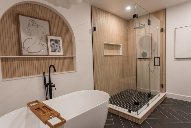 Bathroom showcases an arched nook adorned with the same tile that is used on the shower walls. #Bathroom #archednook #tile #showerwall