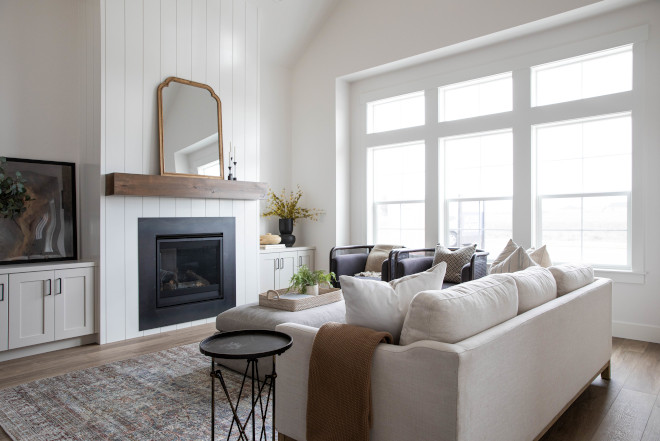 The great room is highlighted with a vaulted ceiling and anchored by a full-height shiplap fireplace #greatroom #homedecor #homeideas #modernorganic