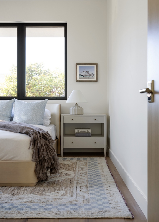 This guest bedroom emphasizes calm and soft textures that seem to invite you in Using a mix of light calming shades like beige taupe soft blues and off-white while incorporating different textures this space feels layered and welcoming while being uncomplicated.