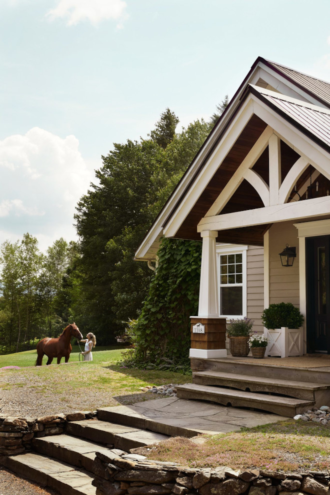 Front porch of a French country home featuring white X-detail planters, tapered columns, and country views