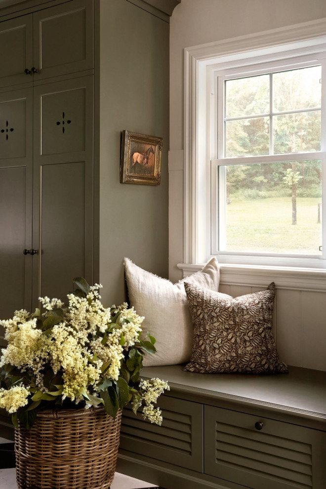 Custom mudroom cabinetry in Benjamin Moore Louisburg Green paired with marble-look checkered floors and custom mudroom bench