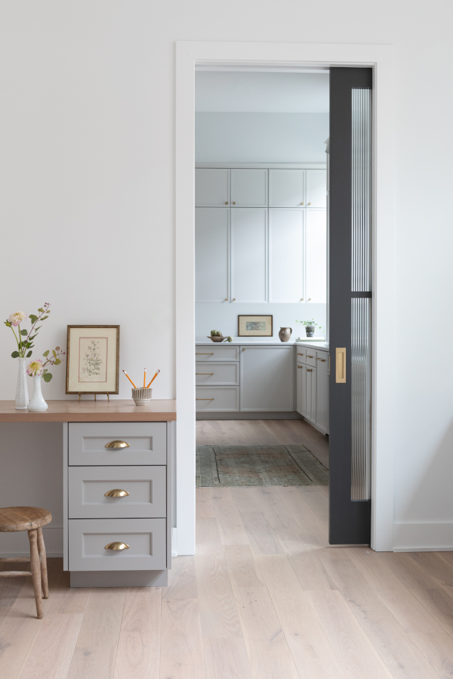 Command center with built-in desks and cabinets painted Sherwin Williams Warm Pewter in a new construction home.