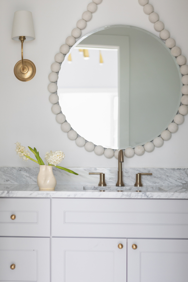 Daughter’s bathroom with Sherwin Williams Essential Gray cabinets, brass accents, and a soft neutral palette.