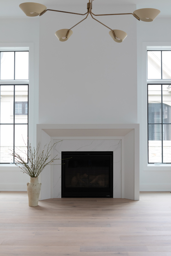 Great room fireplace with jumbo mitered surround painted Sherwin Williams Heron Plume and Benjamin Moore Chantilly Lace walls.