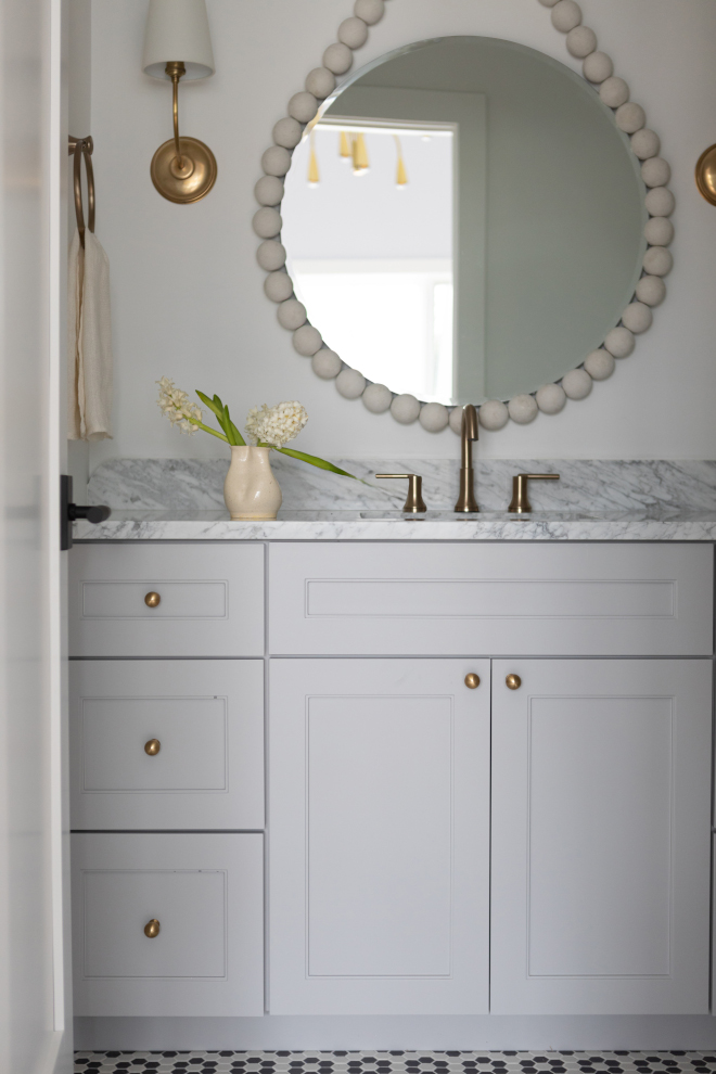Bathroom vanity painted Sherwin Williams Essential Gray with brass hardware and neutral finishes.
