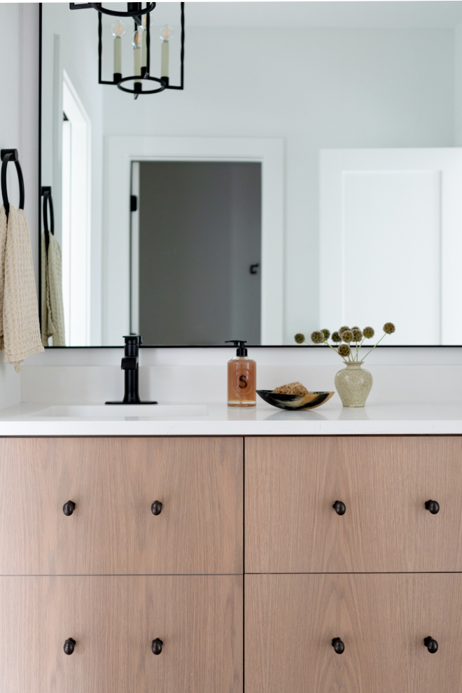 Jack and Jill bathroom with custom white oak vanity, slab doors, and black hardware accents.