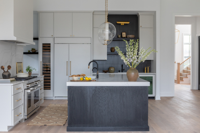 Kitchen island with custom ebony stain and reeded wood detailing, adding texture and contrast to a neutral new construction kitchen.