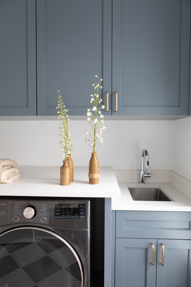 Laundry room cabinets painted Sherwin Williams Outerspace paired with Benjamin Moore Chantilly Lace walls and quartz countertops.