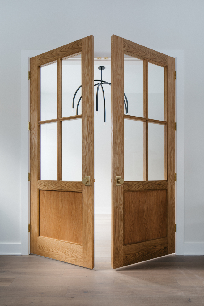 2026-new-home-primary-bedroom-vanilla-milkshake-walls-oak-doors Primary bedroom with double white oak doors and walls painted Benjamin Moore Vanilla Milkshake in a 2026 new construction home.