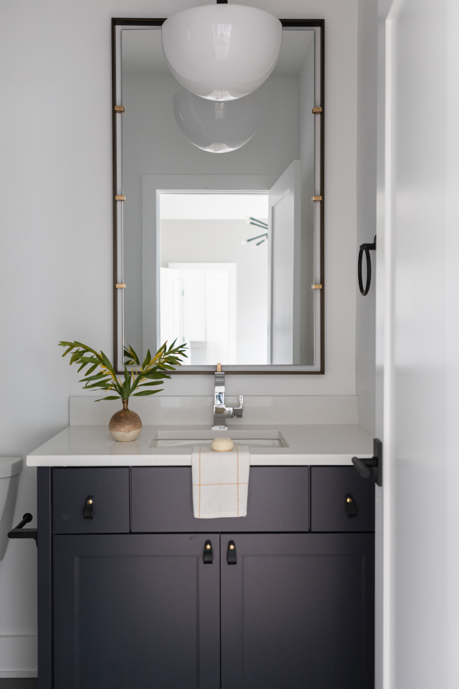 Son’s bathroom with cabinets painted Sherwin Williams Cyberspace, leather pulls, and modern lighting.