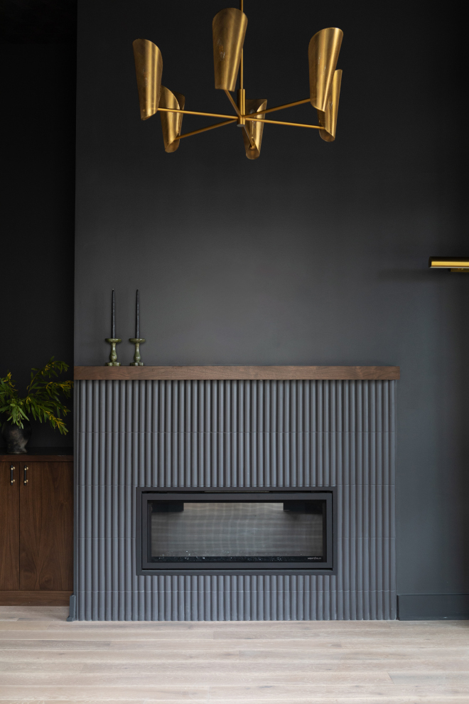 Main floor study with dark, moody walls painted Benjamin Moore Graphite and a modern brass chandelier.