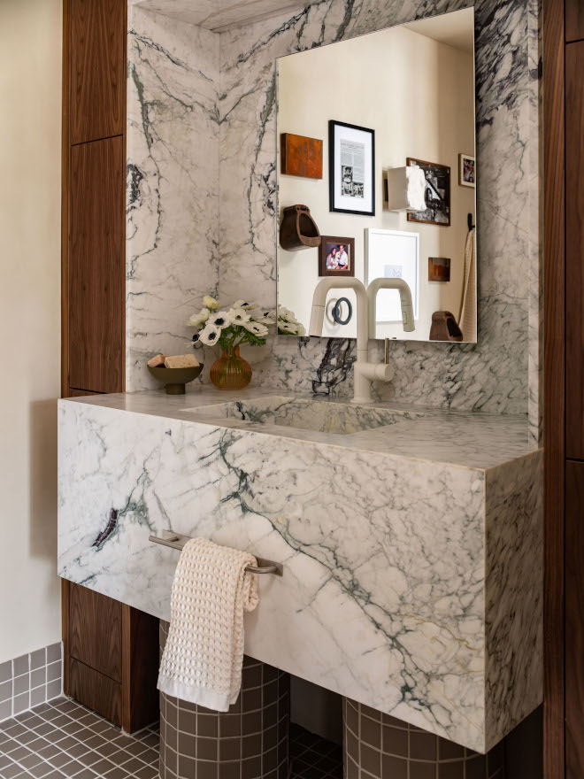 Close-up of bathroom vanity with mitered Calacatta Vagli marble countertop, integrated sink, and tiled vanity legs, highlighting craftsmanship and mid-century modern design details.