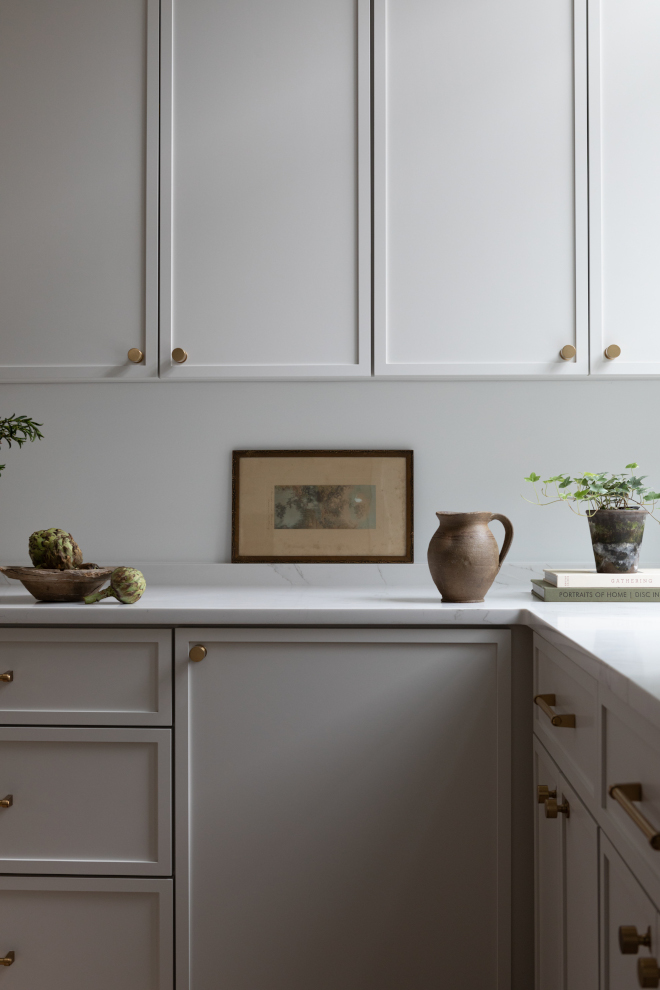 Close-up of kitchen cabinets painted Sherwin Williams Heron Plume showing cabinet hardware and neutral countertop details.