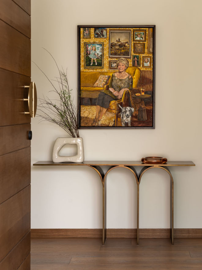 Mid-century modern foyer in Arizona home with curated brass console, curved legs, art that complements warm earthy tones, and a welcoming, effortless design.