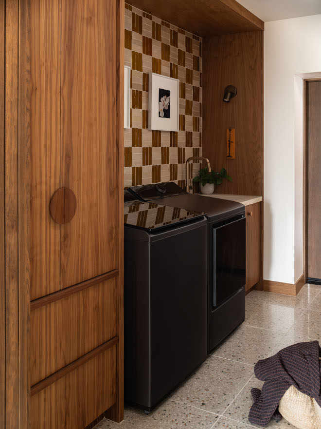 Laundry niche with custom walnut cabinetry, washer, dryer, laundry sink, and zellige crosshatch tile backsplash.