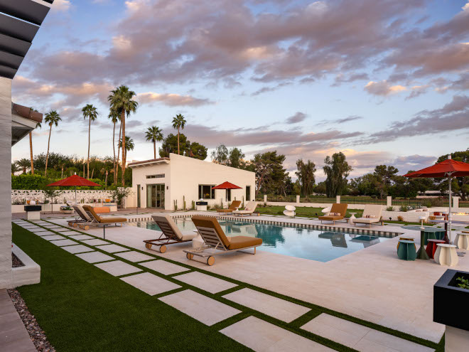 View of backyard pool and guest casita with full kitchen, bedroom, and bathroom, surrounded by natural landscaping and lounge chairs.