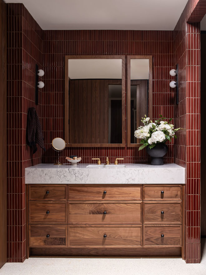 Custom walnut vanity with drawers tucked into niche, offset Silestone Helix countertop, pencil mosaic backsplash tile, creating personality-filled mid-century modern space.