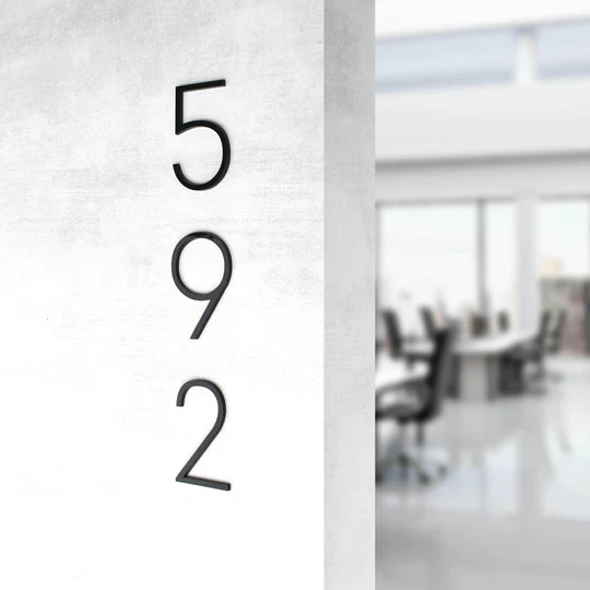 Modern apartment number signs installed on interior hallway doors