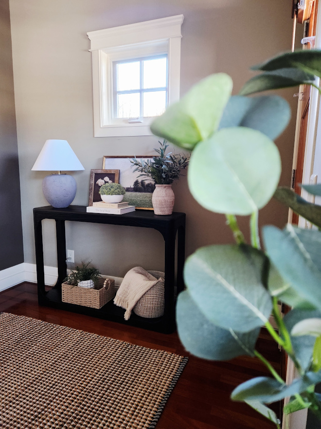 Console-Table-with-round-corner Black console table with soft rounded corners and a lower storage shelf styled with woven baskets.