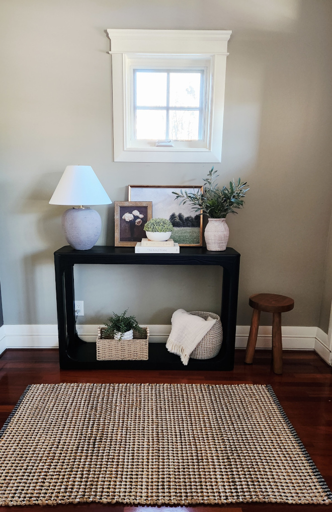 How-to-Create-a-Warm-Welcoming-Foyer-with-a-Neutral-Entryway-and-Styled-Console-Table Warm, welcoming foyer with a neutral entryway featuring a styled black console table, jute rug, and layered décor.
