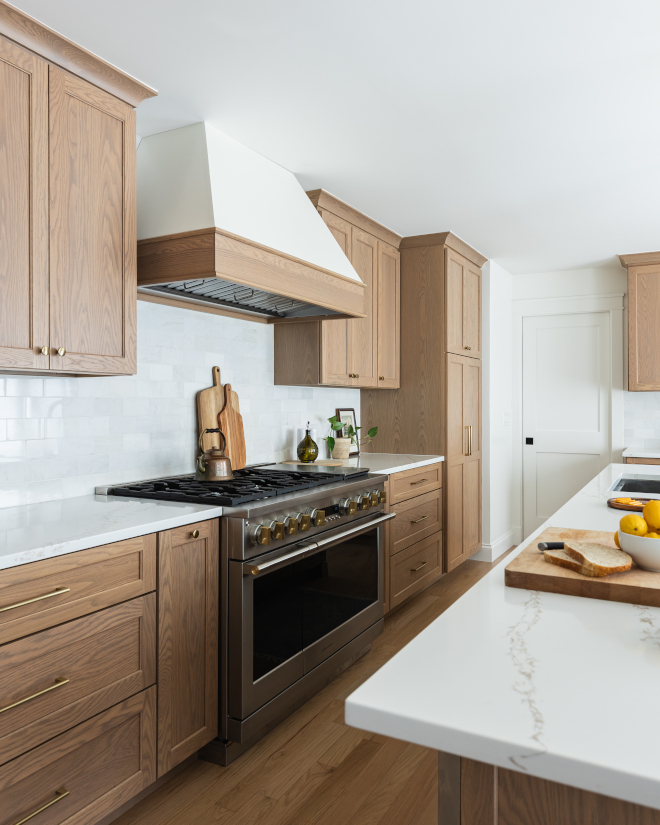 Kitchen-Custom-Cabinet-Details Custom white oak cabinets stained in Minwax Weathered Oak, 3x6 marble subway tile backsplash, satin brass hardware, and Benjamin Moore White Dove range hood in updated kitchen