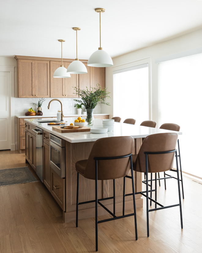 Kitchen-Island-White-Oak-Seating-Six Long white oak kitchen island stained in Minwax Weathered Oak with quartz countertop and seating for six, surrounded by Benjamin Moore White Dove walls in remodeled kitchen