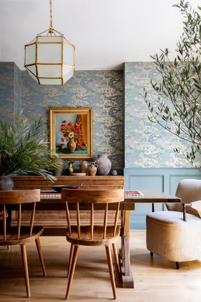 Elegant dining room in a mountain home with hardwood floors and blue metallic pastoral wallpaper, creating a warm, French-inspired ambiance