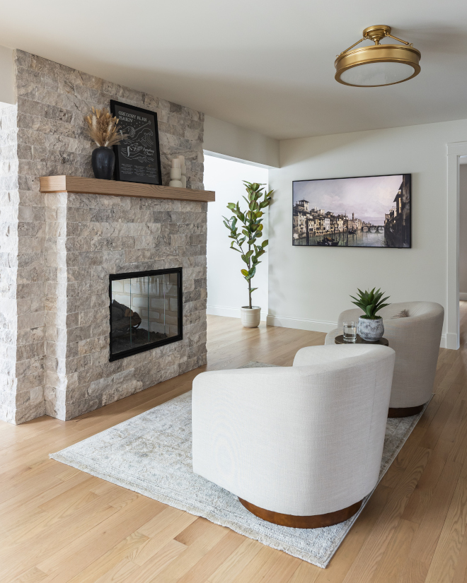 Renovated-fireplace-with-stacked-stone-surround Renovated fireplace with stacked stone surround, solid wood mantel, and swivel seating