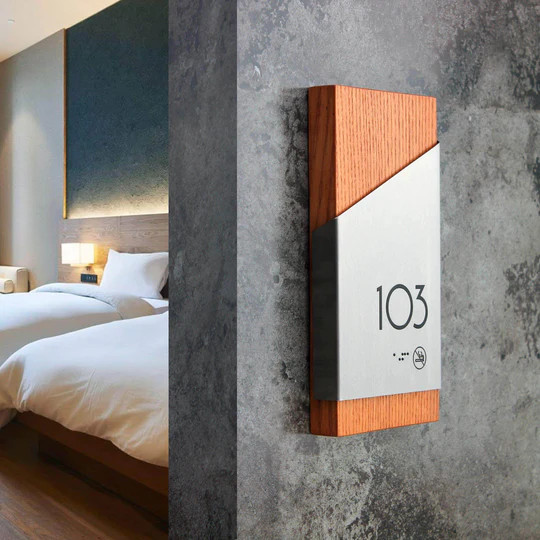 Apartment number sign combining stainless steel and wood, mounted on a residential door for durable and stylish design