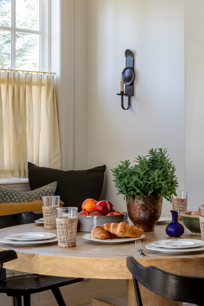 Elegant breakfast table in a French Country mountain home, set with fresh fruit, croissants, and seagrass glasses