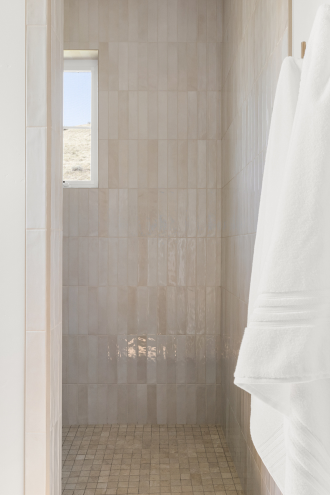 Guest bathroom shower with stacked vertical neutral tiles