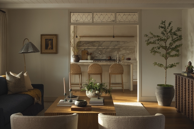 This beautifully crafted white oak waterfall coffee table features intricate box-joint detailing. Styled with antique accessories and design books, it adds craftsmanship and character to the relaxed living room.