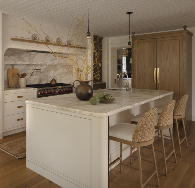 kitchen island with curved edges painted Benjamin Moore Ballet White and marble countertop in warm neutral kitchen