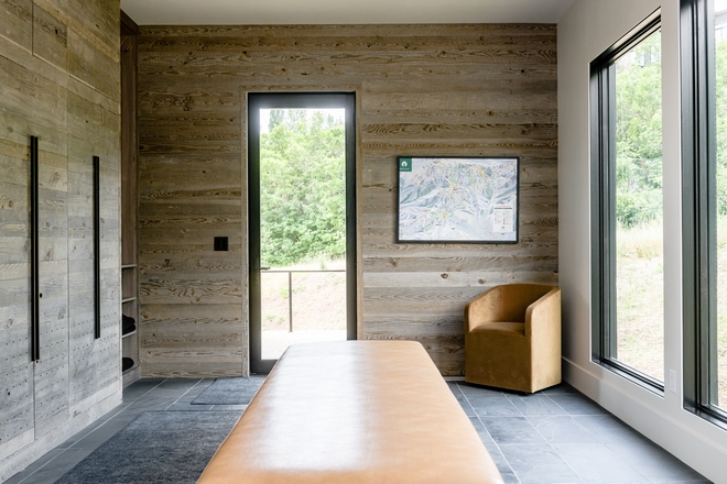mountain home mudroom with wood accent walls, bench seating and large windows