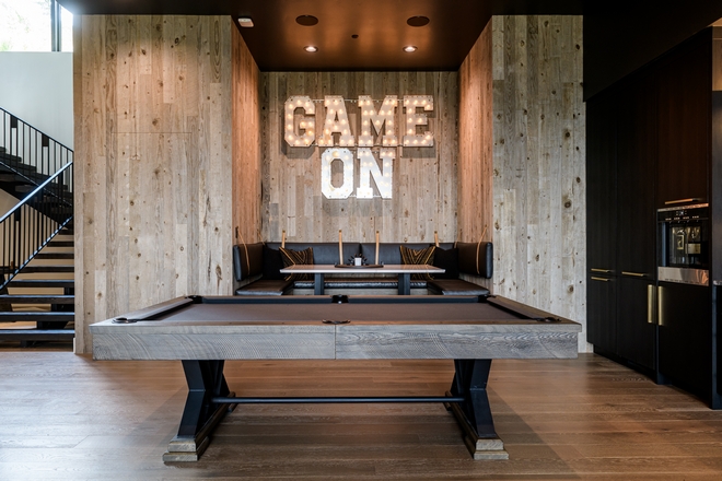 modern game room with pool table, wood walls and lounge seating