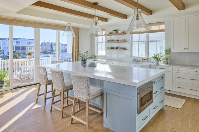 Coastal kitchen island painted Benjamin Moore Santorini Blue with woven stools and glass pendant lighting