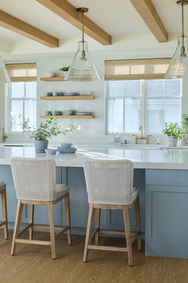 Coastal kitchen island painted Benjamin Moore Boothbay Gray with woven stools and glass pendant lights