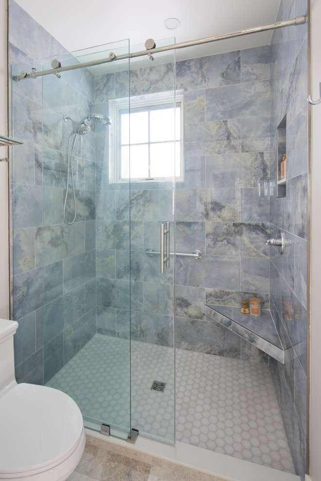 Coastal bathroom shower with blue marble-look tile and frameless glass enclosure.