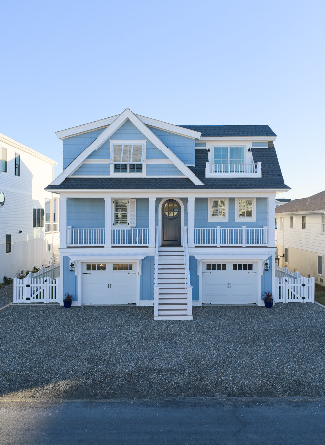 Multi-story blue coastal beach house with layered decks and waterfront entertaining spaces.
