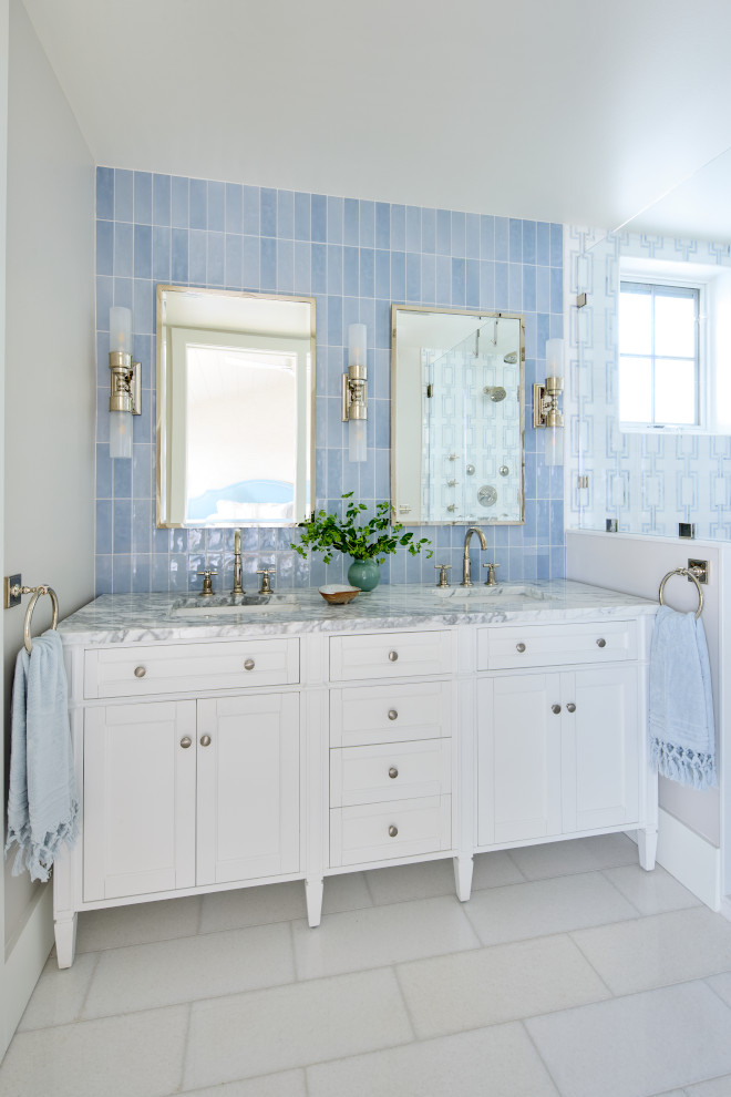 Beach house bathroom with blue vertical tile, white vanity, and marble countertop