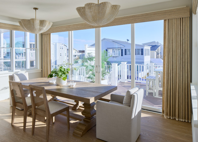 Coastal dining room with woven chandeliers, waterfront views, and Benjamin Moore White Dove walls