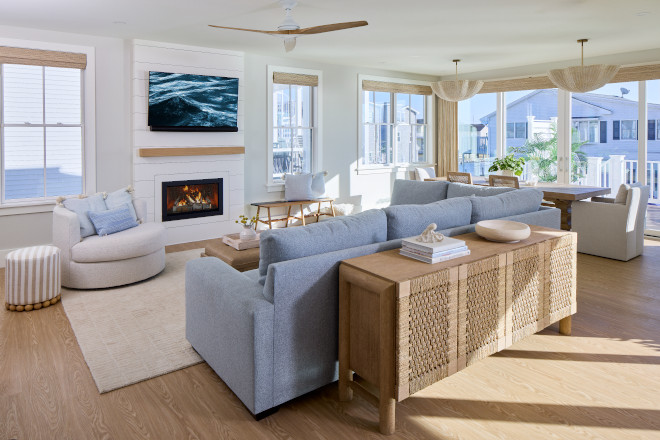 Coastal living room with pale blue sofas, woven console table, fireplace, and Sherwin Williams Drift of Mist walls