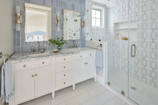 Coastal bathroom with white vanity, marble countertop, and soft blue shower tile