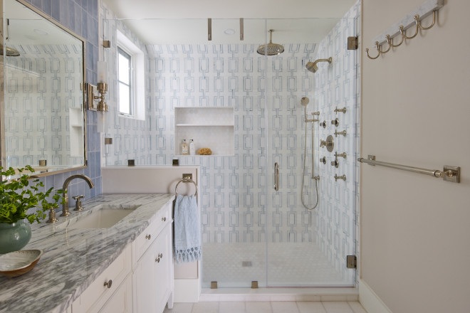 Coastal walk-in shower with soft blue geometric tile and glass enclosure