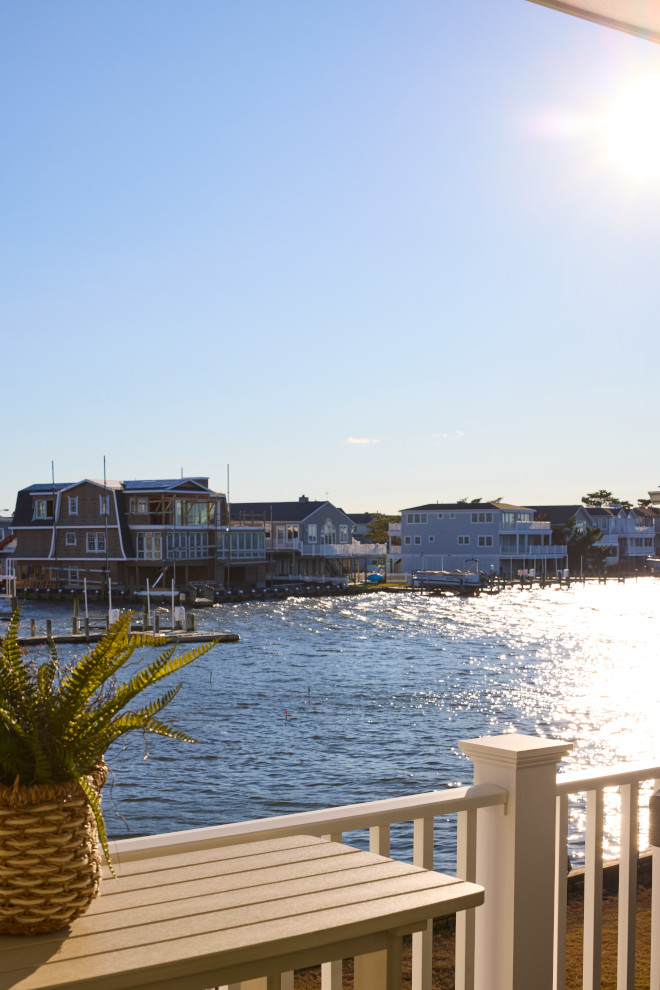 Waterfront bay views from coastal beach house deck during sunset.