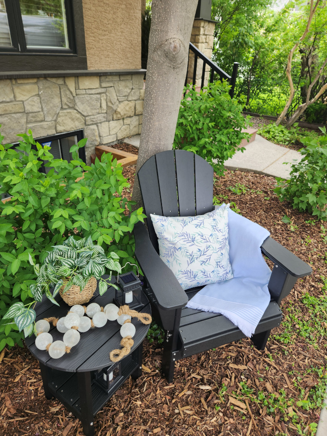 Adirondack chairs styled with blue and white pillows and coastal-inspired accessories in a peaceful outdoor seating area.