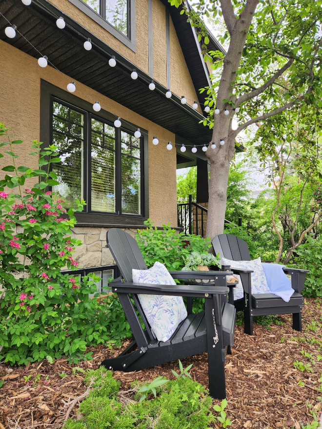 Adirondack chairs styled in soft blue tones with layered outdoor textiles creating a coastal-inspired retreat.