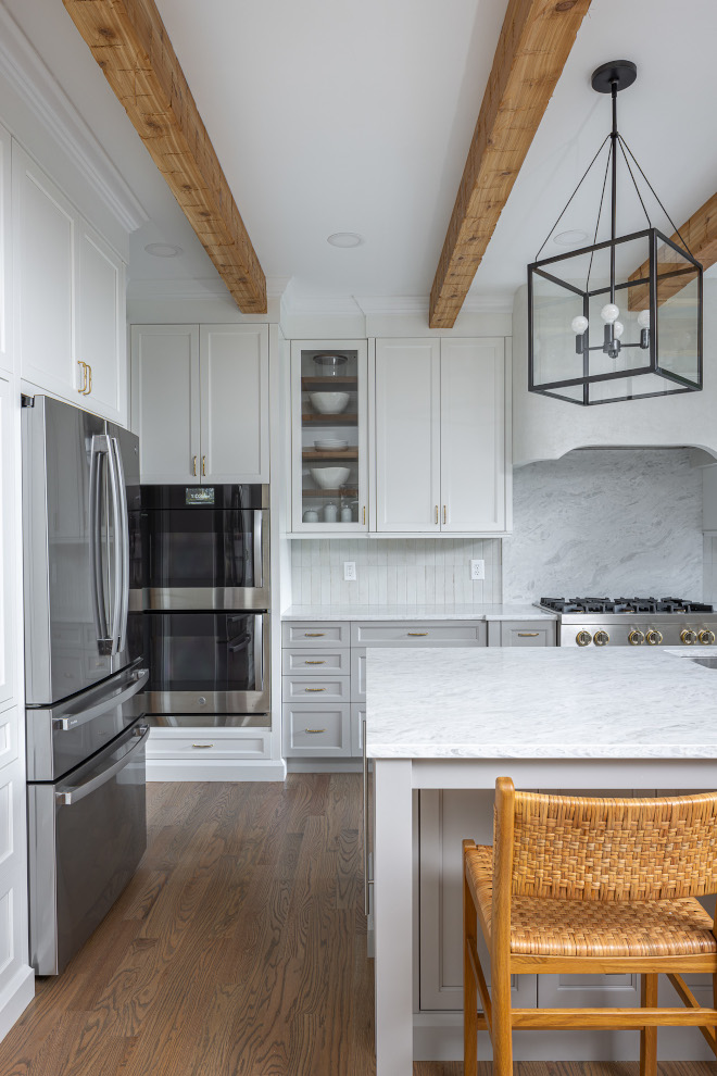 benjamin-moore-steam-gray-owl-kitchen-cabinets-close-up Close-up of Benjamin Moore Steam upper cabinets and Benjamin Moore Gray Owl lower cabinets in a timeless kitchen with wood beams, brass hardware, and a plaster range hood.